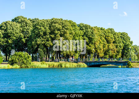 Kalmar, Schweden - 10. August 2016: Park mit Bäumen hinter einer der vielen Brücken in der Stadt. Menschen gehen auf die Brücke. Feine Summe Stockfoto