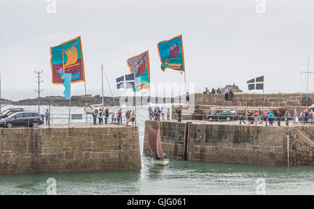 Meer Salze & Segel, farbigen Fahnen im Wind, Mousehole Hafen, Cornwall, UK. Stockfoto