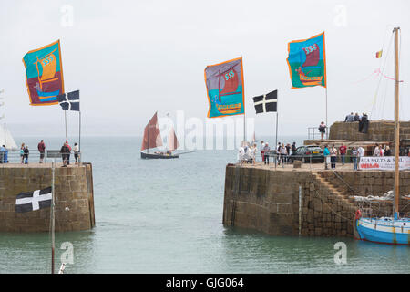 Meer Salze & Segel, farbigen Fahnen im Wind, Mousehole Hafen, Cornwall, UK. Stockfoto