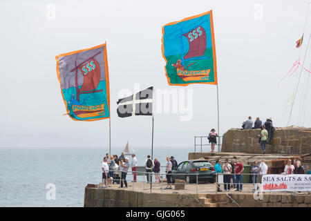 Meer Salze & Segel, farbigen Fahnen im Wind, Mousehole Hafen, Cornwall, UK. Stockfoto