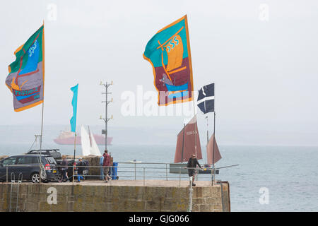 Meer Salze & Segel, farbigen Fahnen im Wind, Mousehole Hafen, Cornwall, UK. Stockfoto