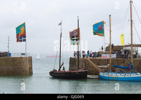 Meer Salze & Segel, farbigen Fahnen im Wind, Mousehole Hafen, Cornwall, UK. Stockfoto