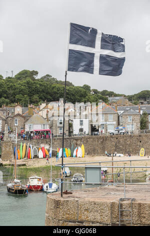 Flagge von Cornwall in den Hafen von Mousehole, Cornwall, UK. Stockfoto