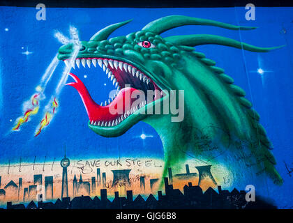 Detail einer Feuer Atmung Drachen Graffiti Wandmalerei an der Berliner Mauer, East Side Gallery, Friedrichshain, Berlin, Deutschland. Stockfoto