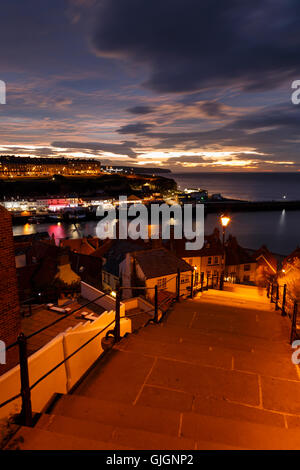 Whitby Stadt und der berühmten "199 Stufen" am Abend gegen einen dramatischen Sonnenuntergang. In Whitby, North Yorkshire, England. 12. a Stockfoto