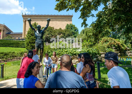 Menschen zu ihren Foto mit der Bronzestatue von Sylvester Stallone als Rocky Balboa außerhalb des Philadelphia Museum of Art Warteschlange. Stockfoto