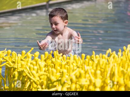 Edinburgh, Schottland. 16. August 2016. UK Wetter: Vierjährige spielt alte Samuel Surlit von Edinburgh in die Teiche in-Front des schottischen Parlaments, dem Edinburgh International Festival Kunstinstallation, etwas, dass gibt aus Licht zu sehen ist. Bildnachweis: Richard Dyson/Alamy Live-Nachrichten Stockfoto