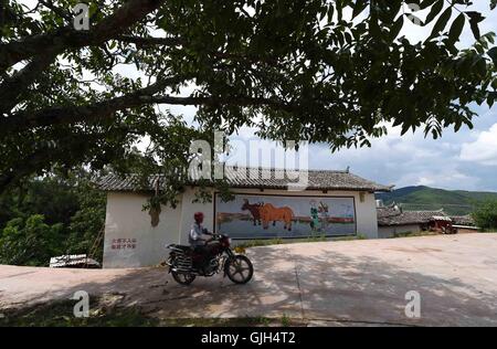 Dayao, chinesischen Provinz Yunnan. 16. August 2016. Ein Dorfbewohner fährt ein Motorrad im Shuijing Yi Dorf unter Liuju Stadt von Dayao County, Chuxiong Yi autonomen Präfektur, der südwestlichen chinesischen Provinz Yunnan, 16. August 2016. Gemeindeverwaltung hat große Anstrengungen unternommen, die wohnen Bedingungen, Umwelt sowie wirtschaftlichen Einkommen für Dorfbewohner in den vergangenen Jahren zu verbessern. © Yang Zongyou/Xinhua/Alamy Live-Nachrichten Stockfoto