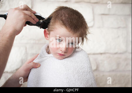 Junge, eine Summen Haare schneiden von seinem Vater Stockfoto