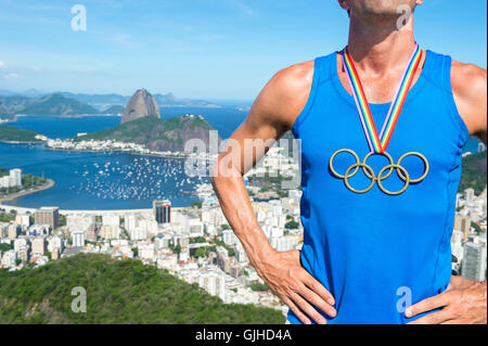 RIO DE JANEIRO - 26. Februar 2016: Olympische Ringe gold Medaille hängt von gay-Pride-Regenbogen-Band ein Athlet auf die Skyline. Stockfoto