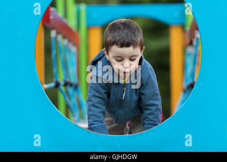 Junge auf Klettern Spielgerät auf Spielplatz Stockfoto