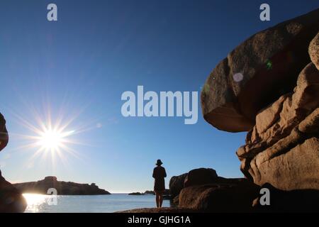 Frau auf Felsen am Strand, Bretagne, Frankreich Stockfoto