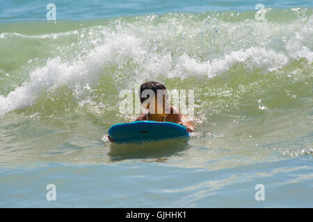 Junge auf Surfbrett im Ozean Stockfoto