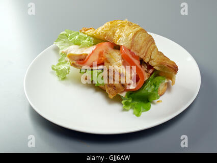 Sommermorgen Frühstück Croissant gefüllt, Hähnchenfilet und Gemüse Stockfoto