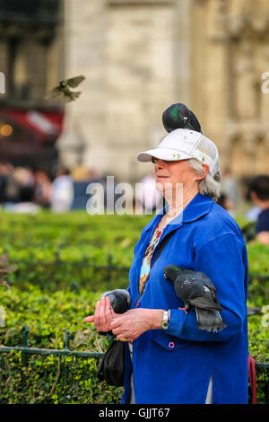 Frau in Paris mit Vögel auf ihren Kopf und Arm. Stockfoto