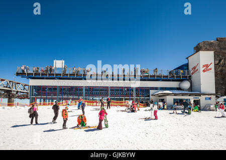 Menschen ruht auf Schnee vor der Seilbahn Talstation Hintertuxer Gletcher an einem sonnigen Tag Stockfoto