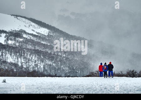 Drei Menschen bewundern die schöne Schneelandschaft angesehen von der Spitze des Hügels Bayo. Stockfoto