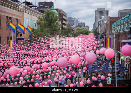 Montreal, CA - 14. August 2016: Rosa Kugeln über Rue Sainte Catherine im Gay Village von Montreal mit schwulen Regenbogenfahnen Stockfoto