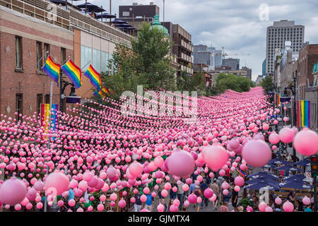 Montreal, CA - 14. August 2016: Rosa Kugeln über Rue Sainte Catherine im Gay Village von Montreal mit schwulen Regenbogenfahnen Stockfoto