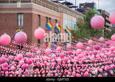 Montreal, CA - 14. August 2016: Rosa Kugeln über Rue Sainte Catherine im Gay Village von Montreal mit schwulen Regenbogenfahnen Stockfoto