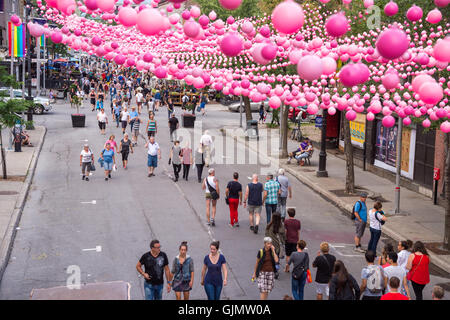 Montreal, CA - 14. August 2016: Rosa Kugeln über Rue Sainte Catherine im Gay Village von Montreal mit Homosexuell Regenbogenfahnen und Stockfoto