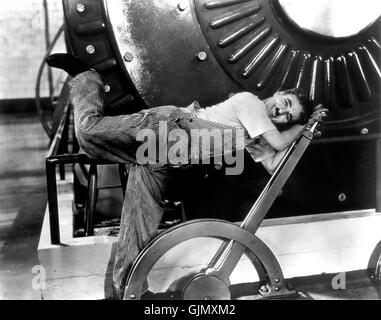Ein Standbild aus Charlie Chaplins legendärem Film *Modern Times* aus dem Jahr 1936, in dem die satirische Haltung des Films zur Industrialisierung und ihre Auswirkungen auf die Arbeiter, insbesondere in der Fließbandszene, hervorgehoben wird. Der Film zeigt Chaplin als Tramp, der die Herausforderungen moderner Maschinen und Gesellschaft meistern kann. Stockfoto