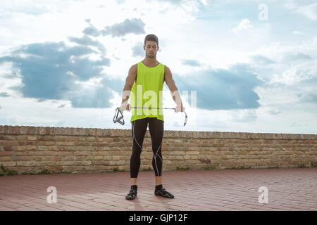 Junger Mann Fitness Band Krafttraining stretching Himmel Stockfoto