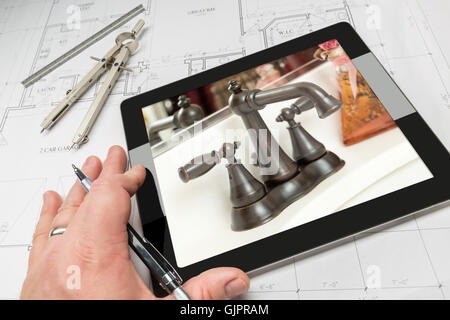 Hand des Architekten auf Computer Tablet zeigt Luxus Badezimmer Details über Hauspläne, Zirkel und Lineal. Stockfoto