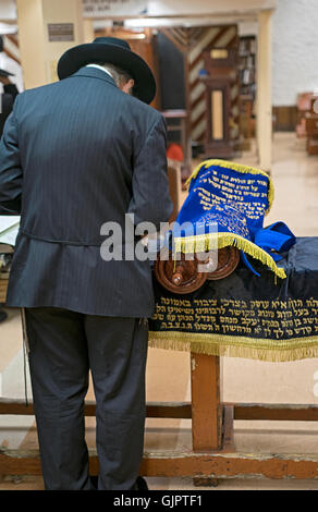 Ein religiösen jüdischer Mann steht in der Nähe einer Tora auf eine Synagoge in Crown Heights, Brooklyn, New York Stockfoto