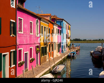 Hell gestrichene Terrassenhäuser am Canalside auf der Insel Burano. Venedig, Italien. Stockfoto