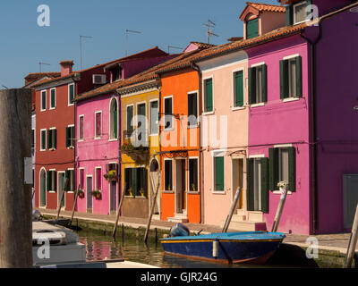 Hell gestrichene Terrassenhäuser am Canalside auf der Insel Burano. Venedig, Italien. Stockfoto