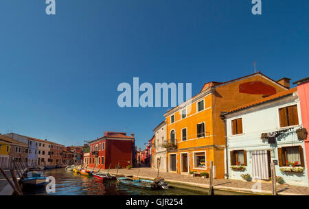 Hell gestrichene Terrassenhäuser am Canalside auf der Insel Burano. Venedig, Italien. Stockfoto