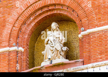 Marmorstatue der Heiligen Jungfrau Maria und das Jesuskind auf dem Giebel der katholischen Kirche in Italien Stockfoto