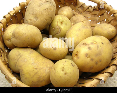 Korb mit Kartoffeln auf einer beigen Decke Stockfoto