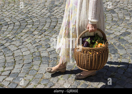 Belgrad, Serbien - Lady Wanderungen vom grünen Markt hält einen Korb voller Lebensmittel in Sommermorgen Stockfoto