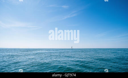 Ein Segelschiff am Horizont von der irischen See, in der Nähe von Rhosneigr, aus Anglesey, Ynys Mon, North Wales, UK Stockfoto