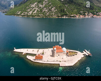 Luftbild auf künstliche Insel Gospa od Skrpjela (Our Lady of the Rocks) und Küste von Perast Stadt. Bucht von Kotor. Montenegro Stockfoto