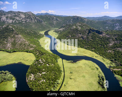 Luftaufnahme des Wasserlaufs Biegung des Rjieka Crnojevica. Schönheit Natur des Flusses in Bergen. Teil von Skadar See und Nationalpark Stockfoto