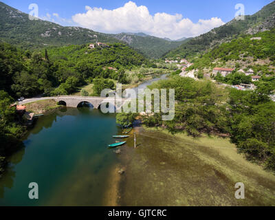 Kleinstadt liegt am Fluß Crnojevica mit Bogen Brücke über. Nationalpark in Montenegro Stockfoto