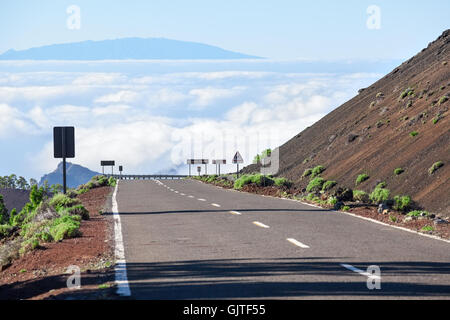 Leere Asphalt Bergstraße hinunter in weißen Wolken. Weiterleitung an den Teide Vulkan, Teneriffa, Kanaren Inseln, Spanien Stockfoto