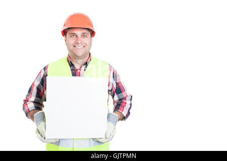 Glückliche junge Baumeister isoliert halten ein leeres Feld mit Werbefläche und lächelnd auf weißem Hintergrund Stockfoto