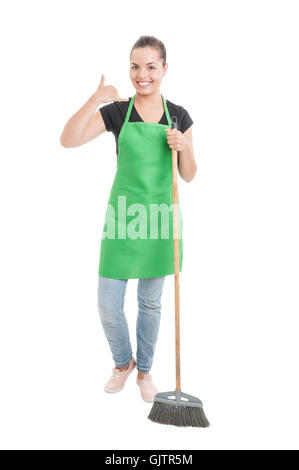 Freudige Reinigung Mädchen mit Schürze tun eine Anruf Geste während der Reinigung des Hauses isoliert auf weißem Hintergrund Stockfoto
