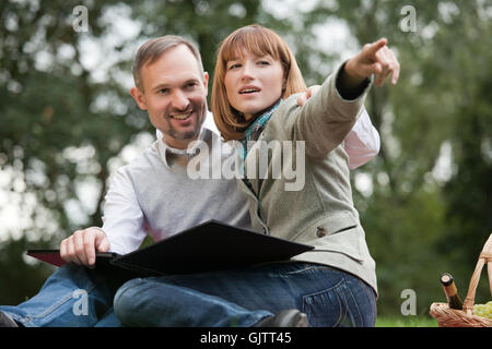 Frau mit Fotoalbum zeigt mit finger Stockfoto