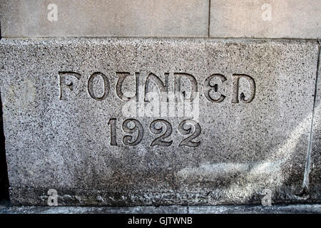 Worte "Gegründet 1922" geschnitzt in einem Stein einer Wohnhaus-Wand. Stockfoto