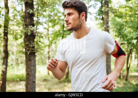 Hübscher junger Mann Athlet im Wald laufen Stockfoto