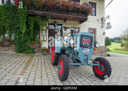 Eicher Diesel Oldtimer-Traktor vor dem Gasthaus Lindl geparkt bedeckt mit blühenden Geranien, Bayern, Deutschland Stockfoto