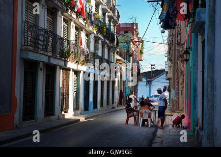 eine typische kubanische Versammlung von ein paar Nachbarn über ein Tischspiel, die in einer der Straßen von Alt-Havanna Stockfoto