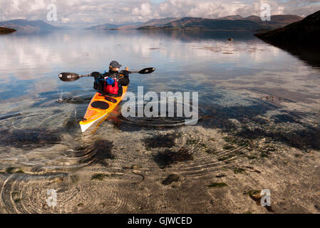 Ein Kajakfahrer Meer in einer einsamen Bucht auf der Insel Lismore in den Inneren Hebriden im Westen Schottlands. Stockfoto