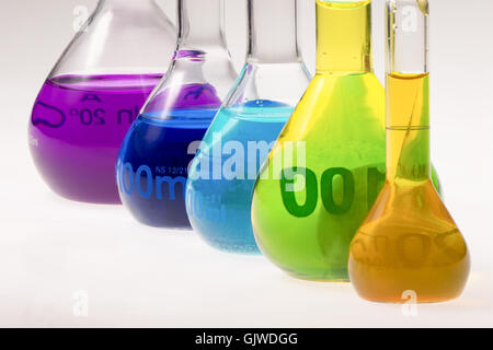 farbige Lösungen in chemischen Kolben hintereinander Stockfoto