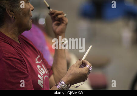 Elgin, Florida, USA. 8. November 2016. eine Frau zeigt die ' Knochen '' als sie Hand-Spiel während der Messe in Elgin, Oklahoma Comanche spielt. Die beiden Teams spielen Handspiel können variieren in der Größe, jedes Team (das Team '' versteckt '' und '' erraten '' Team) müssen einen Kapitän. Das Spiel ist mit zwei Paaren von "Bones", jedes Paar bestehend aus einer Ebene und einem gestreiften Knochen gespielt. Jeder Stamm entscheidet welche Knochen wird erraten, unifarben oder gestreiften Knochen. Oklahoma-Indianer nennen in der Regel für den gestreiften Bone. Die beiden Teams, ein '' versteckt '' und 1 '' raten, '' sitzen einander gegenüber; zwei Mitglieder der " Stockfoto